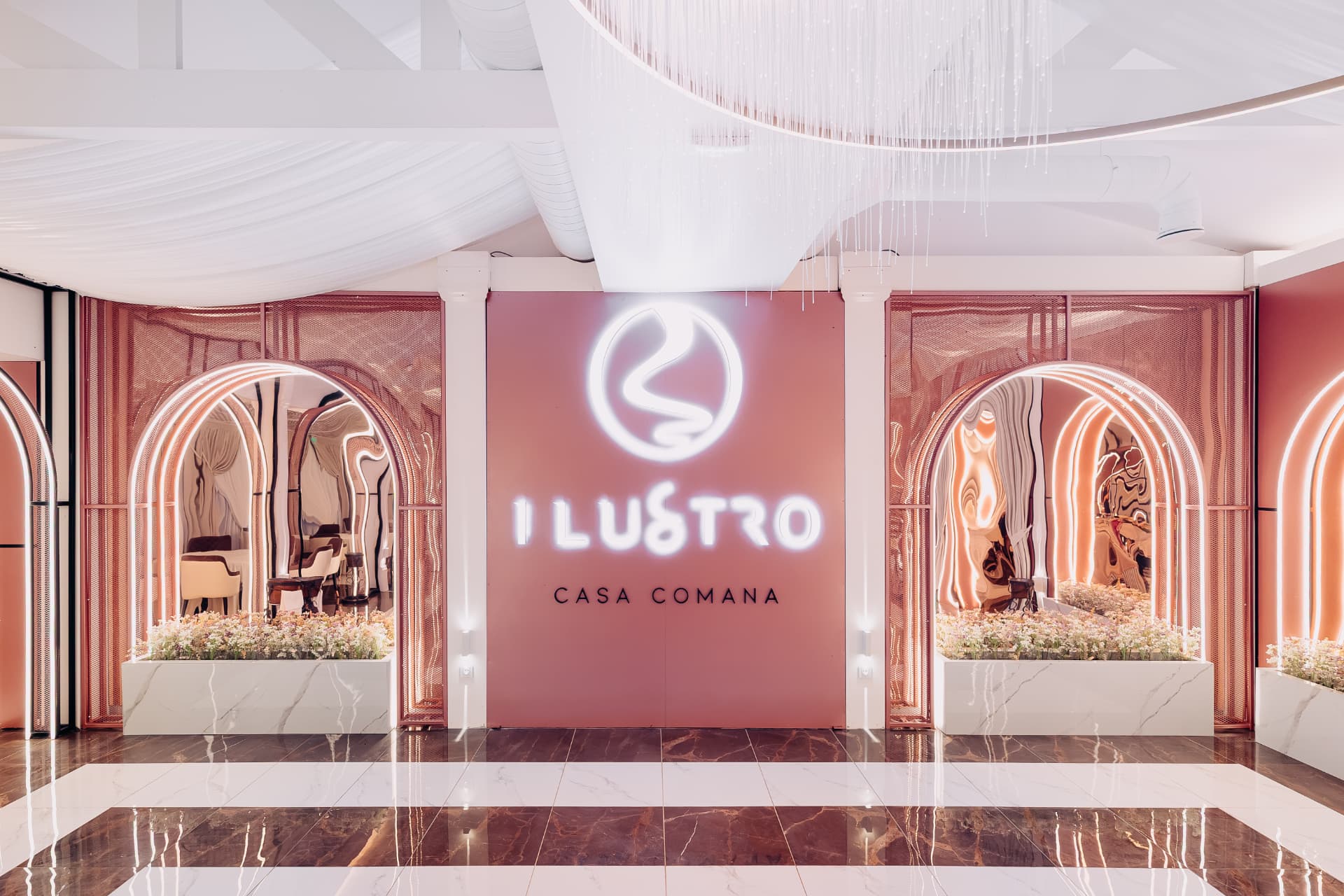 Intrarea salonului Ilustro, cu arcade rose gold și decor floral